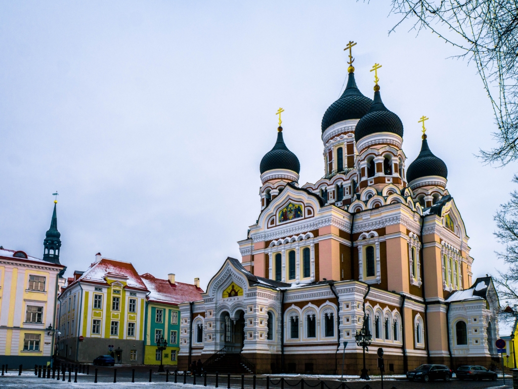 Photo of Alexander Nevsky Cathedral, a grand colourful Russian Orthodox building with an onion-domed structure painted in pinks and yellows.