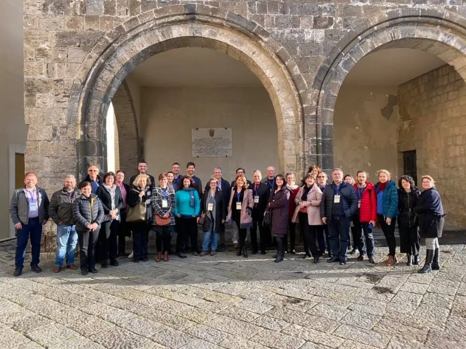 Undergroud4value group photo in front of an ancient stone building with arches