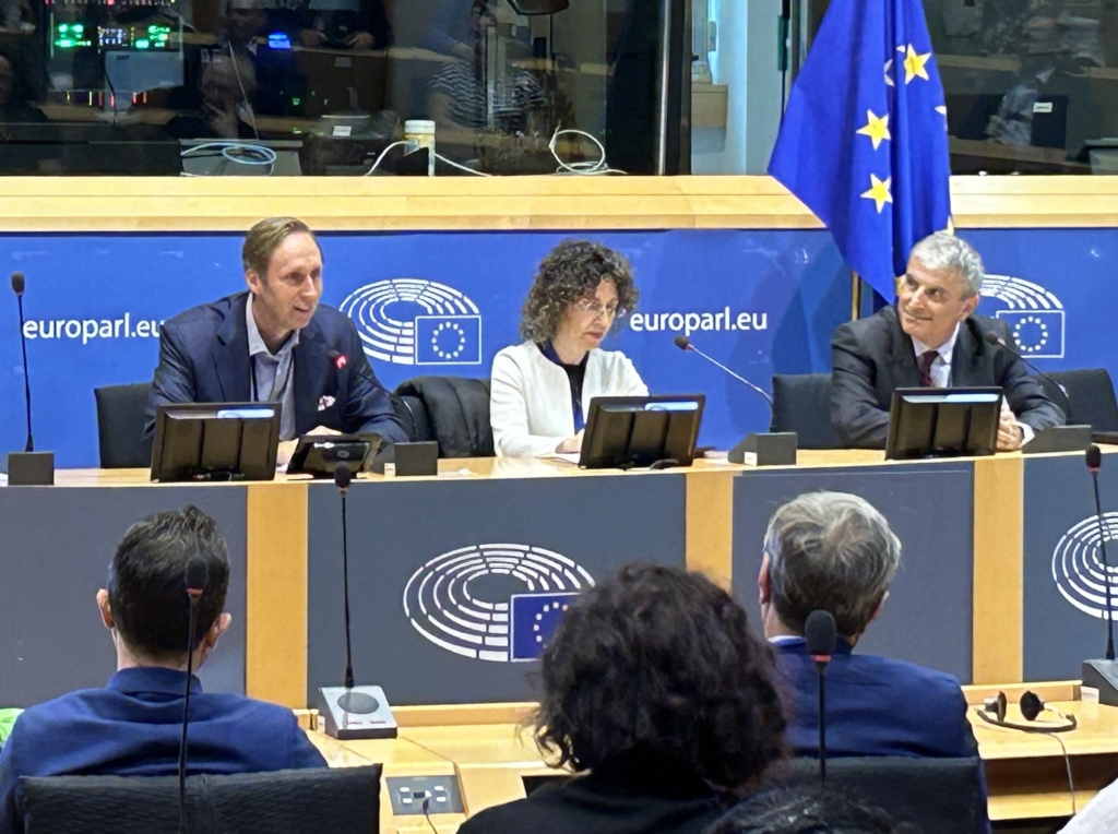 conference speakers on a stage in front of the audience