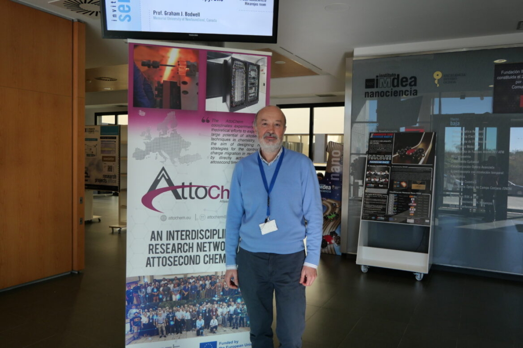 Photo of a man standing in front of a poster