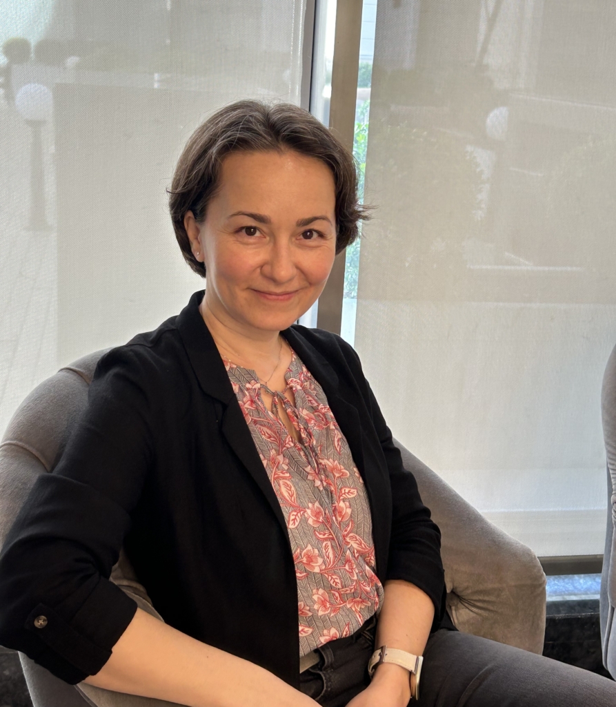 A woman with short hair is sitting and smiling