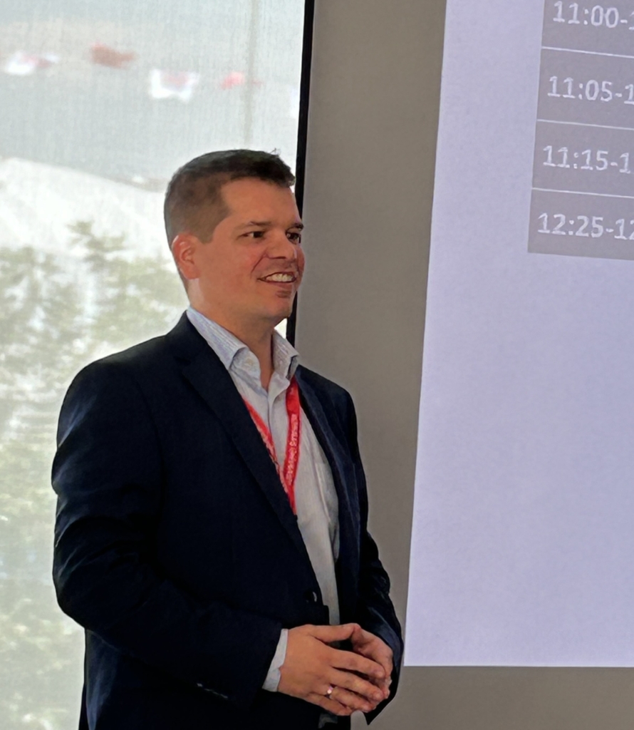 A smiling young man gives a presentation 