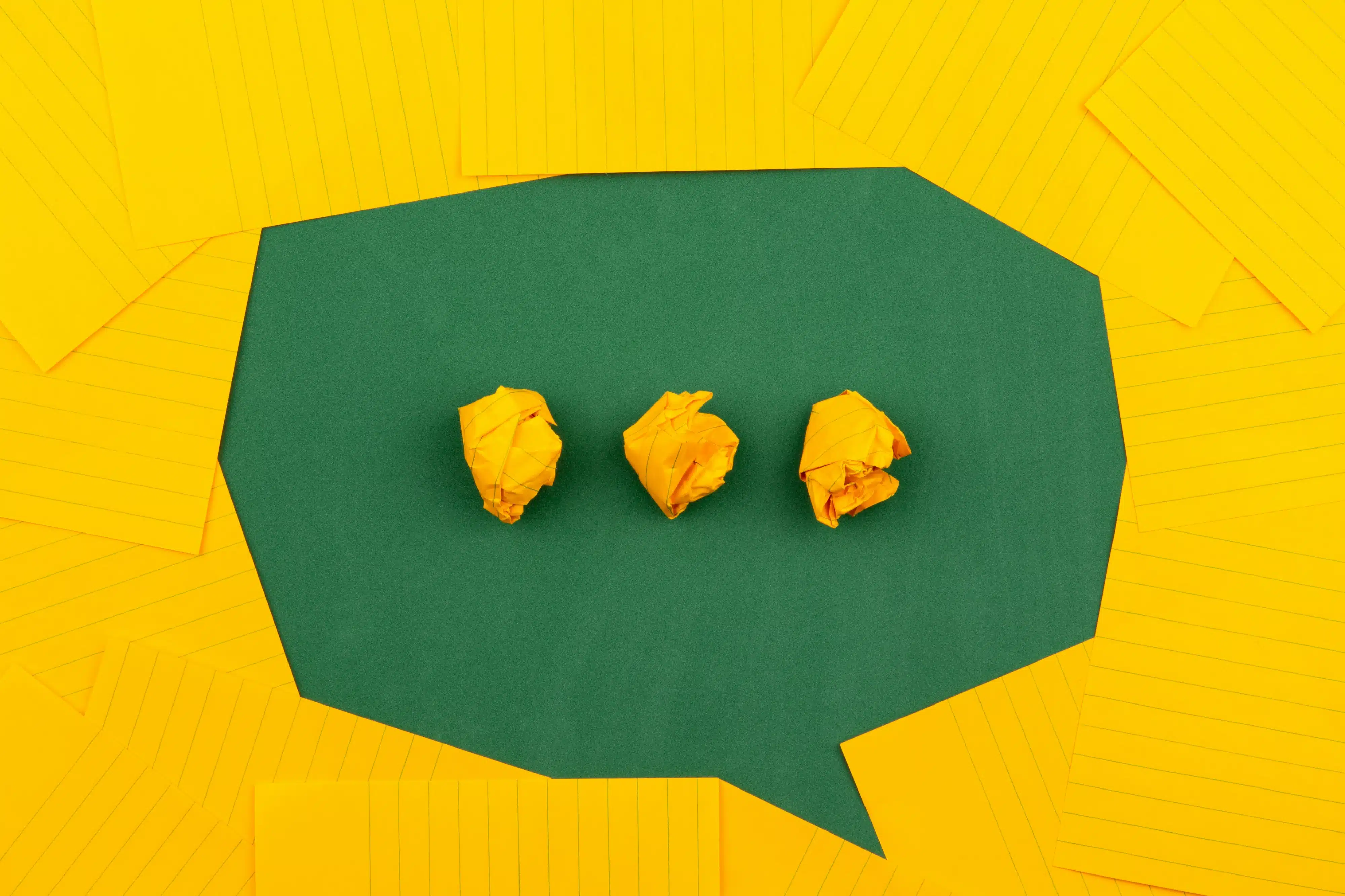 A speech bubble made from different shaped pieces of bright yellow paper